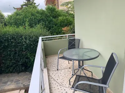 a patio with a table and chairs on a balcony at Awesome Home 3' from Metro (M3) Station Agia Paraskevi in Athens