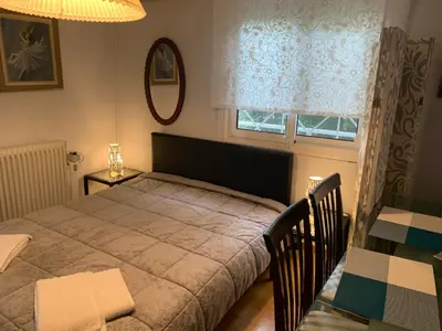 a bedroom with a bed and a table and a window at Awesome Home 3' from Metro (M3) Station Agia Paraskevi in Athens