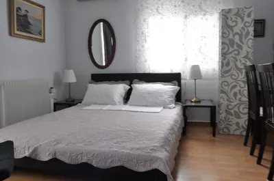 a bedroom with a bed with white sheets and a mirror at Awesome Home 3' from Metro (M3) Station Agia Paraskevi in Athens