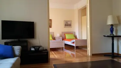 a living room with a couch and a tv and a bedroom at ACROPOLIS MUSEUM APARTMENT in Athens