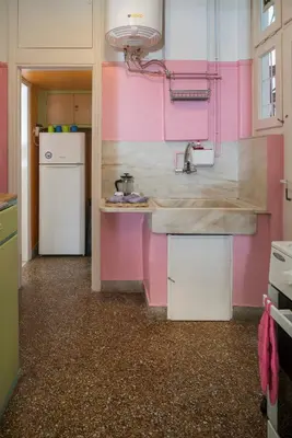 a pink kitchen with a sink and a refrigerator at ACROPOLIS MUSEUM APARTMENT in Athens