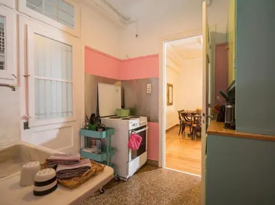 a small kitchen with a refrigerator and a table at ACROPOLIS MUSEUM APARTMENT in Athens
