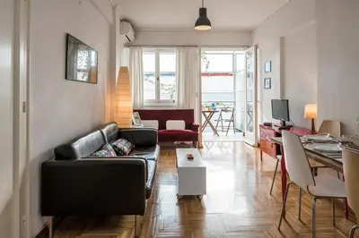 a living room with a leather couch and a table at ULTIMATE LOCATION CENTRAL ATHENS in Athens