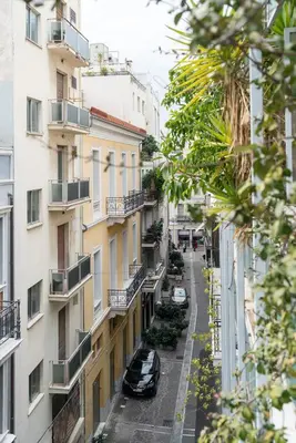 an apartment street in a city with cars parked on the street at ULTIMATE LOCATION CENTRAL ATHENS in Athens