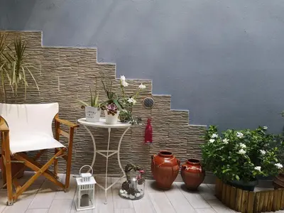 a patio with a table and chairs and plants at Perfect View in Piraeus