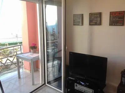 a living room with a television and a balcony at Perfect View in Piraeus