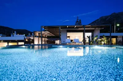 a large swimming pool in front of a house at night at Luxury Beachfront Villa Selenia Platinum in Sounio in Sounio