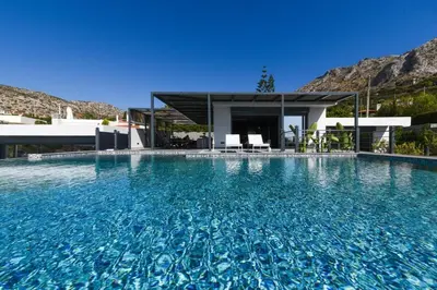 a swimming pool in front of a house at Luxury Beachfront Villa Selenia Platinum in Sounio in Sounio