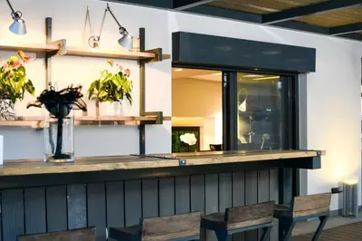 a bar with two chairs and a counter with plants at Luxury Beachfront Villa Selenia Platinum in Sounio in Sounio