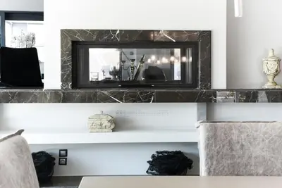 a living room with a mirror above a fireplace at Luxury Beachfront Villa Selenia Platinum in Sounio in Sounio
