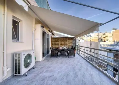 a balcony with an air conditioner and a table on it at Elea Athens Apartment in Athens