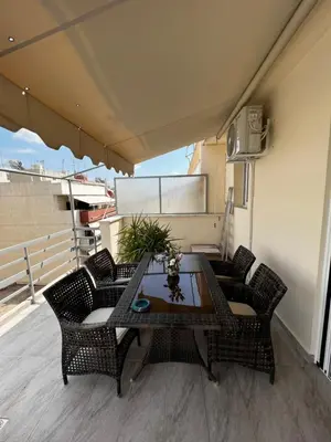 a patio with a table and chairs on a balcony at Elea Athens Apartment in Athens