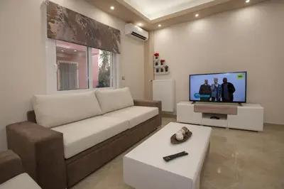 a living room with a couch and a flat screen tv at Spacious & convenient place near Acropolis Museum by GHH in Athens