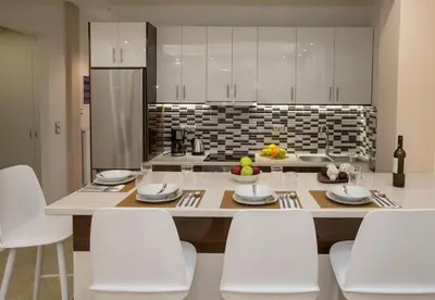 a kitchen with a large table with white chairs at Spacious & convenient place near Acropolis Museum by GHH in Athens