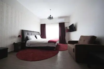 a bedroom with a bed and a couch and a window at MARGARITA'S SUITES in Athens