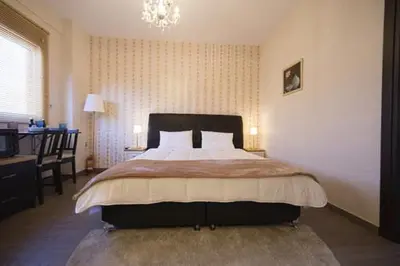 a bedroom with a large bed and a chandelier at MARGARITA'S SUITES in Athens