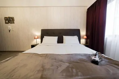 a large bed in a bedroom with two lamps at MARGARITA'S SUITES in Athens