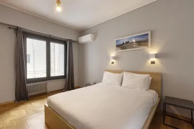 a bedroom with a white bed and a large window at Super modern minimal flat nr metro & arch. Museum in Athens
