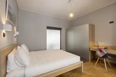 a bedroom with a white bed and a desk at Super modern minimal flat nr metro & arch. Museum in Athens