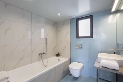 a bathroom with a tub and a toilet and a sink at Super modern minimal flat nr metro & arch. Museum in Athens
