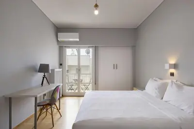a bedroom with a large white bed and a desk at Super modern minimal flat nr metro & arch. Museum in Athens