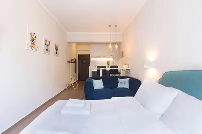 a living room with a bed and a blue couch at luxury kolonaki studio in Athens