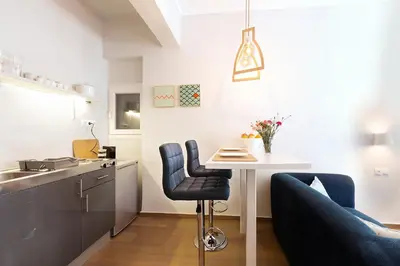 a small kitchen with a table and a blue couch at luxury kolonaki studio in Athens