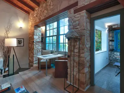 a living room with a stone wall and a table at Live at the Acropolis shadow - under super scenic Anafiotika in Athens