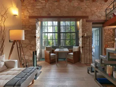 a living room with a bed and a table and windows at Live at the Acropolis shadow - under super scenic Anafiotika in Athens