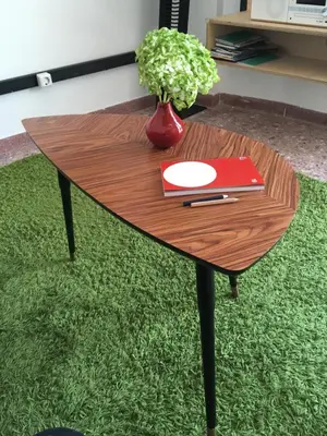a wooden table with a book and a plant on it at Semedaki, design in the centre of history in Athens