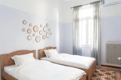 two beds in a room with white walls and a window at Acropolis Heights at the foot of the Parthenon in Athens