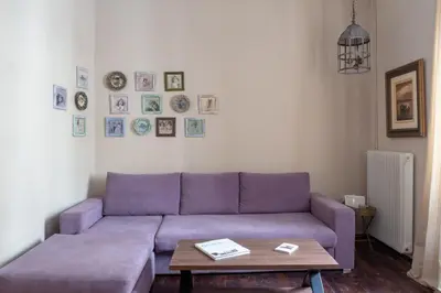 a purple couch in a living room with a table at Acropolis Heights at the foot of the Parthenon in Athens