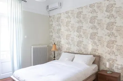 a bedroom with a white bed and a wall at Acropolis Heights at the foot of the Parthenon in Athens