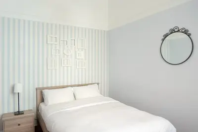 a white bedroom with a bed and a mirror at Acropolis Heights at the foot of the Parthenon in Athens