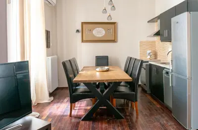 a small kitchen with a wooden table and chairs at Acropolis Heights at the foot of the Parthenon in Athens