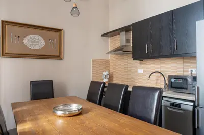 a kitchen with a wooden table and black cabinets at Acropolis Heights at the foot of the Parthenon in Athens