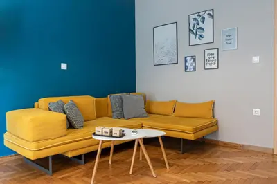 a yellow couch in a living room with a table at Maria's Home in Athens