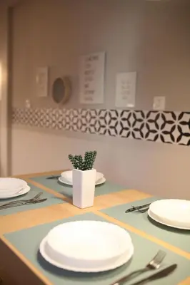 a table with white plates and a potted plant on it at Maria's Home in Athens