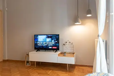 a tv sitting on top of a white cabinet in a room at Maria's Home in Athens