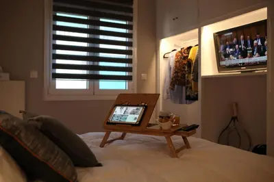 a bed with a table on it with a tablet on it at Maria's Home in Athens