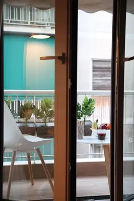 a white chair sitting on a balcony with plants at Maria's Home in Athens