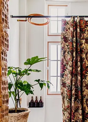 a curtain in a room with a plant and a window at Shila Athens in Athens