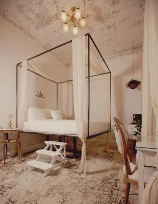 a bedroom with a canopy bed and a chair at Shila Athens in Athens
