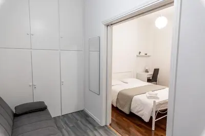 a white bedroom with a bed and a couch at Alkamenous Apartment Petros VIPGreece in Athens