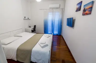 a bedroom with a white bed and a window at Alkamenous Apartment Petros VIPGreece in Athens