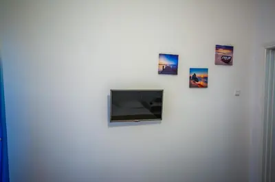 a flat screen tv on a white wall with pictures at Alkamenous Apartment Petros VIPGreece in Athens