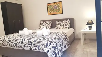 a bedroom with a bed with a black and white comforter at Palette Apartment Champagne - Athens Center, 6 BD, 3 BATH in Athens