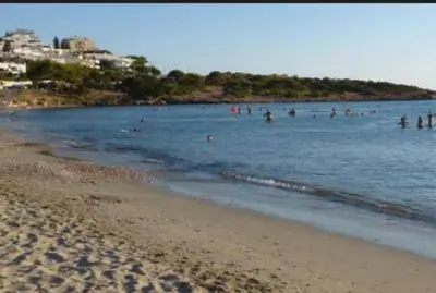 a group of people in the water at the beach at THE BOUCAMVIGLIA BEACH HOUSE in Saronida
