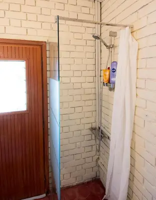 a bathroom with a white brick wall at THE BOUCAMVIGLIA BEACH HOUSE in Saronida