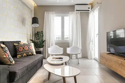 a living room with a couch and a tv at Modern Design Acropolis Flat in Athens
